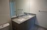 Dual-sink vanity with stone-finish countertop, undermount sinks, tall chrome faucets, and wood-finish cabinetry