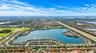 Aerial perspective of a master-planned community encompassing a central lake, expansive waterfront residential lots, integrated street network, and pr