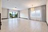 Spacious interior featuring large-format tile flooring, multi-tiered crystal chandelier, and floor-to-ceiling glass sliding doors