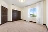 Neutral wall tones, wall-to-wall carpeting, sliding closet doors with dark wood-finish, matching dark wood-finish interior door, and a single-pane win