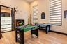Room with wood-finish flooring, high ceilings, dual windows with integrated blinds, and a glass-paneled door