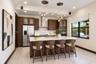Kitchen featuring wood-finish cabinetry, a white quartz countertop island, stainless steel appliances, recessed ceiling lighting, and pendant globe fi