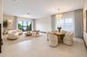 Open-concept interior featuring large-format tile flooring, tiered crystal chandelier, and floor-to-ceiling glass sliding doors
