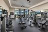 Fitness center featuring rubber flooring, recessed lighting, ceiling fans, full-height wall mirrors, and expansive floor-to-ceiling glass paneling