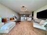 Open-concept interior featuring a sculptural circular ceiling light, a linear multi-pendant fixture, and a built-in media console