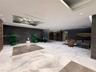 Lobby featuring large-format marble flooring, recessed ceiling lighting with sculptural chandelier, dark stone wall accents, and elevator bank