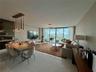Large-format polished tile flooring, floor-to-ceiling glass sliding doors, modern multi-pendant dining chandelier, and geometric ceiling lighting fixt
