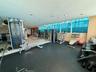 Fitness center featuring expansive floor-to-ceiling windows, rubberized athletic flooring, recessed ceiling lighting, and wood-finish wall paneling