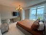 Floor-to-ceiling windows, polished tile flooring, multi-globe chandelier, and built-in cabinetry