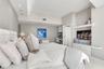 Built-in media console with glass shelving, integrated desk area, recessed lighting, and decorative pendant fixture