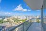 Covered balcony featuring glass paneled railings and large-format tile flooring