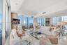 Floor-to-ceiling glass windows, expansive reflective wall paneling, recessed lighting, and polished stone-finish flooring