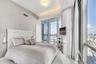Floor-to-ceiling glass windows, recessed ceiling lighting with crown molding, custom curved built-in cabinetry, and tile flooring