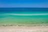 Direct oceanfront access featuring a sandy beach, clear turquoise water, and an expansive horizon