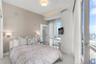 Floor-to-ceiling windows, neutral interior wall palette, polished tile flooring, recessed ceiling lighting, and built-in wall-mounted bedside fixtures
