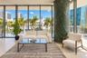 Floor-to-ceiling glass wall, expansive natural light, and structural stone-finished cylindrical column