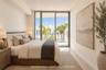 Floor-to-ceiling glass sliding doors, private balcony, neutral wall finishes, and light-toned hard-surface flooring