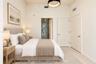 Neutral-toned room featuring high ceilings, a contemporary circular pendant light fixture, and solid-core interior doors with satin nickel hardware