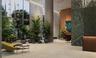 Floor-to-ceiling glass windows, stone-finish flooring, full-height decorative stone wall, wood-finish reception desk, and architectural track lighting