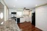 Kitchen featuring black appliances, white cabinetry, washer / dryer, dark wood-style flooring, and recessed lighting