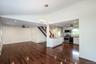 Unfurnished living room featuring ceiling fan, a chandelier, dark wood finished floors, stairway, and vaulted ceiling