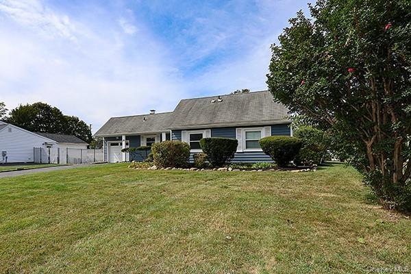 View of front facade featuring a front lawn and an attached garage