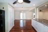 Kitchen featuring light stone counters, a ceiling fan, freestanding refrigerator, open floor plan, and dark wood-style floors