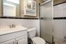 Full bathroom featuring a shower stall, vanity, and tile walls