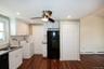Kitchen with tasteful backsplash, black appliances, white cabinets, washer / clothes dryer, and dark wood-type flooring