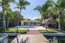 Waterfront property featuring a private dock, swimming pool, paved patio, and thatched-roof tiki structure