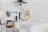 Neutral-toned interior featuring a recessed wall niche with built-in shelving, a modern ceiling fan, a wall-mounted ductless air conditioning unit, an