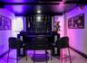 Built-in wet bar featuring multi-level open shelving and a glass countertop