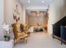 Neutral wall tones, large-format tile flooring, recessed ceiling lighting, multi-tiered pendant lighting, and an industrial-style staircase featuring 