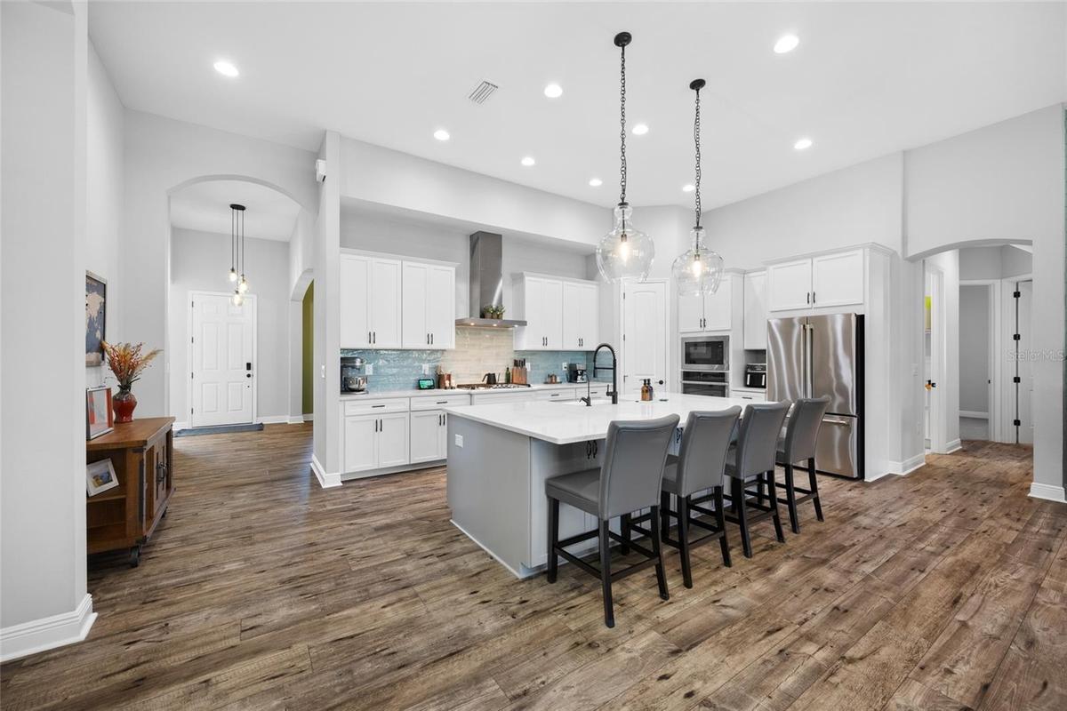 Kitchen with GE Cafe & Profile appliances Gas cooktop & wall oven and 9 foot quartz island
