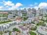 Aerial perspective of a multi-story residential building featuring a structured parking facility, flat roof architecture, and proximity to the urban s