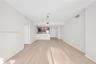 Open-concept interior featuring wood-finish flooring, a kitchen breakfast bar, and track lighting