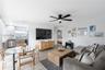 Open-concept living space featuring wood-finish tile flooring, recessed ceiling lighting, a matte black multi-blade ceiling fan, and neutral wall tone