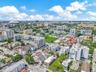 Aerial perspective of a high-density urban environment featuring multi-story residential buildings, paved street grids, landscaped green spaces, and s