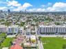 Aerial perspective of the urban landscape featuring mid-rise residential structures, extensive street grid infrastructure, and integrated green spaces