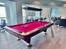 Open-concept space featuring wood-finish flooring, floor-to-ceiling windows, and a rectangular pendant light fixture with a wood-finished frame