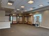 Spacious interior featuring integrated floor-to-ceiling cabinetry, recessed lighting, grid-pattern drop ceiling, and neutral carpeting