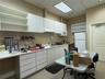 Extensive white cabinetry with upper shelving, solid-surface countertops, built-in sink, and drop-in ceiling lighting