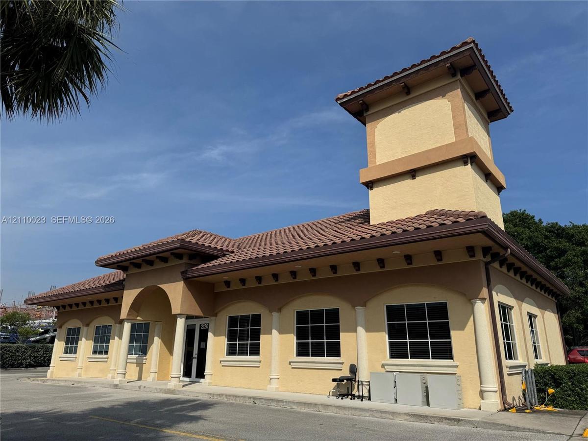 Stucco exterior featuring a prominent tower, mission-style tile roofing, decorative rafter tails, and a covered entry with column detailing