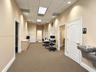 Interior corridor featuring neutral wall finishes, drop ceiling with recessed lighting, carpeted flooring, built-in cabinetry with solid-surface count