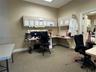 Built-in desk workspace featuring neutral-toned cabinetry, laminate countertops, and acoustic drop ceiling