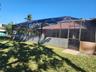 Screened lanai enclosure with a tile roof and brick-paver entry, complemented by an open green space