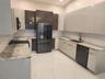 Kitchen featuring two-tone cabinetry with high-gloss finishes, stone countertops, large-format tile flooring, a double-basin undermount sink, and stai