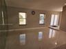 Large-format polished tile flooring, full-height mirrored wall, double-entry glass paneled doors, and dual windows