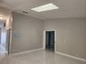 Vaulted ceilings featuring a rectangular skylight, paired with large-format stone-finish floor tiling