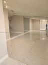 Polished stone-look tile flooring, vaulted ceilings, recessed lighting, and floor-to-ceiling mirrored closet doors